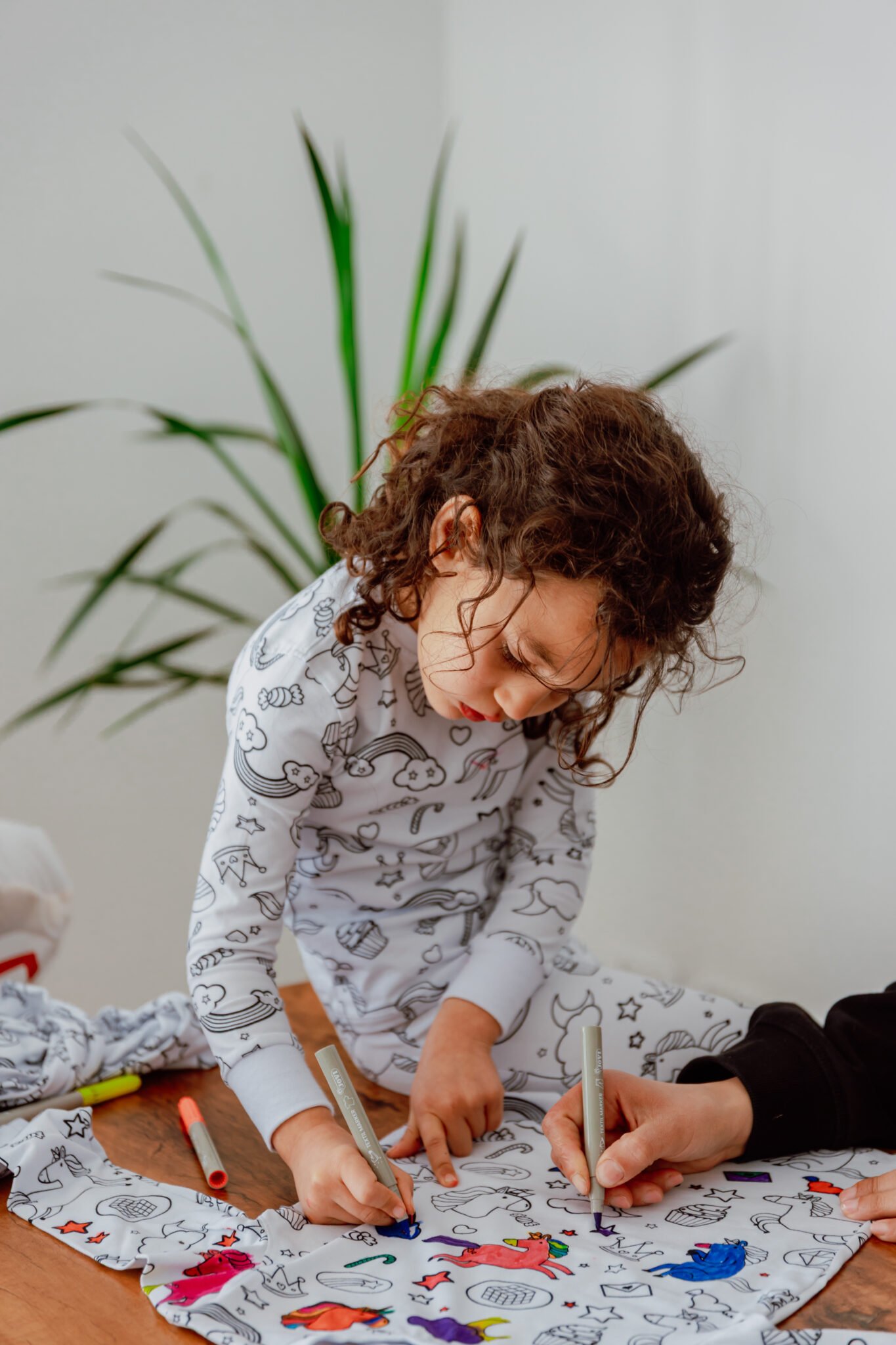 Petite fille colorie son pyjama à colorier